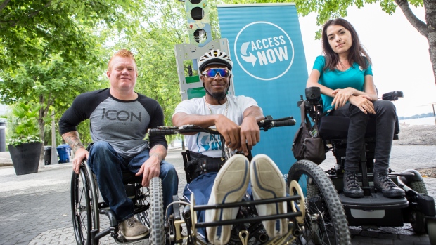 Jeff adams, left, anthony lue, centre, maayan ziv right, pose with accessnow banner. all pictured are wheelchair users.