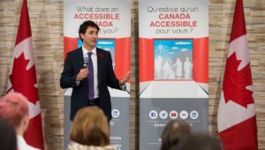 Justin Trudeau delivers address in front of accessible canada banners