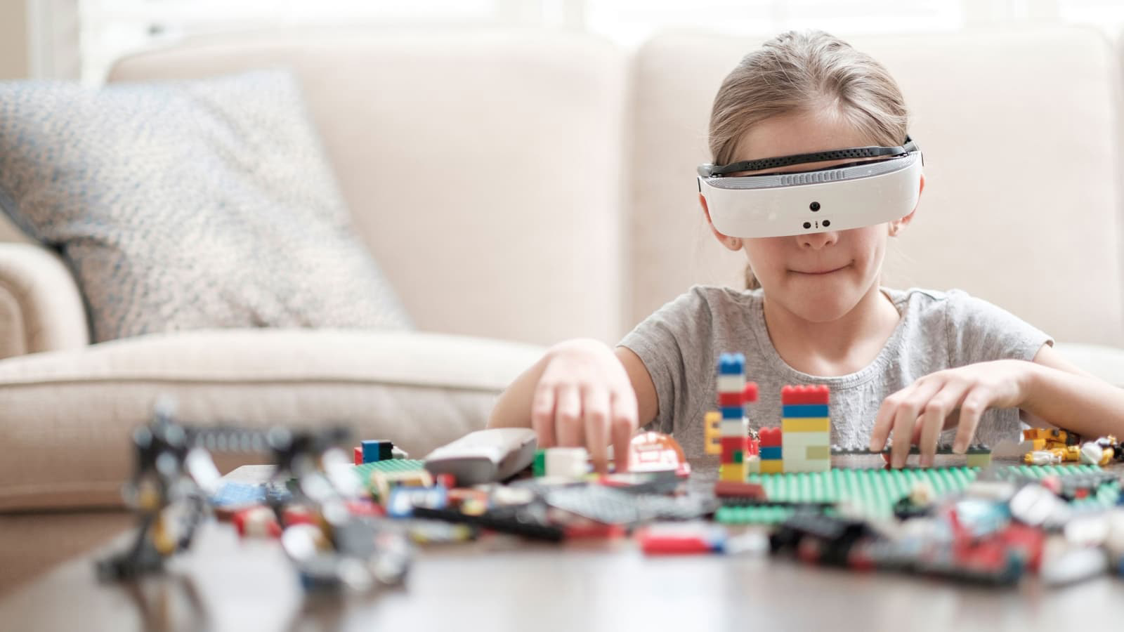 young girl plays with legos while wearing esight visor