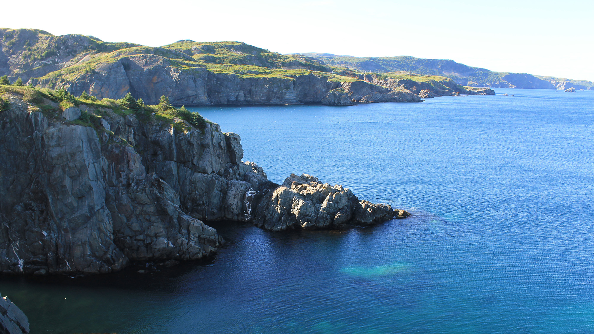 birds eye view of clear blue waters and jagged rocks