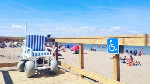beach wheelchair sits on boardwalk with the beach in the background