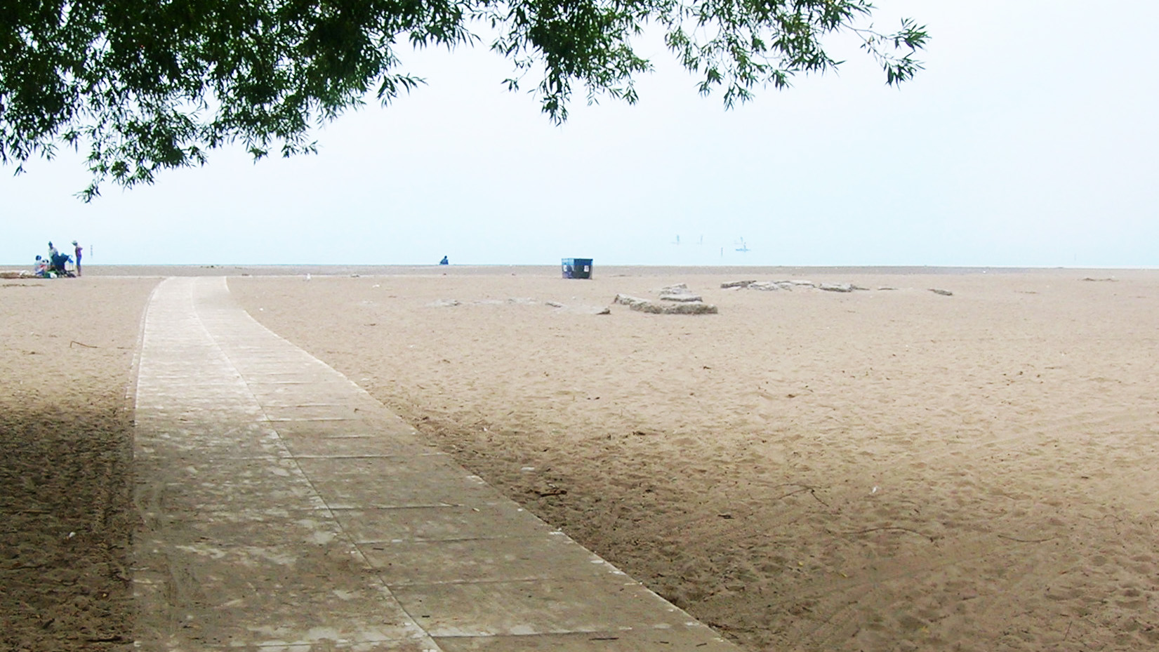 mesh pathway extends over sand towards the water