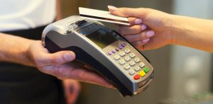 hand tapping a credit card on a payment machine