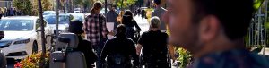 imagine of people using wheelchairs strolling on sidewalk