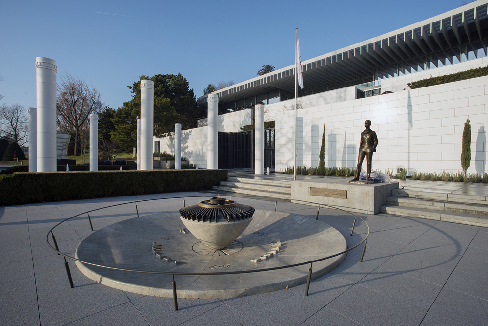 exterior entrance of olympic museum with flame and statue