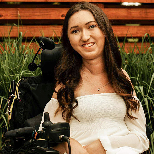 portrait of tori hunter, brunette, smiling in her power wheelchair