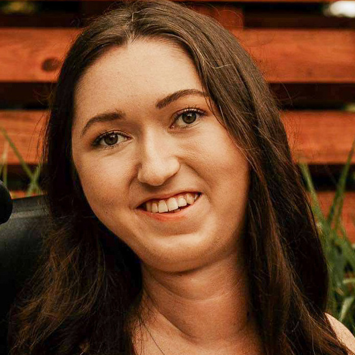 portrait of tori hunter, brunette, smiling in her power wheelchair