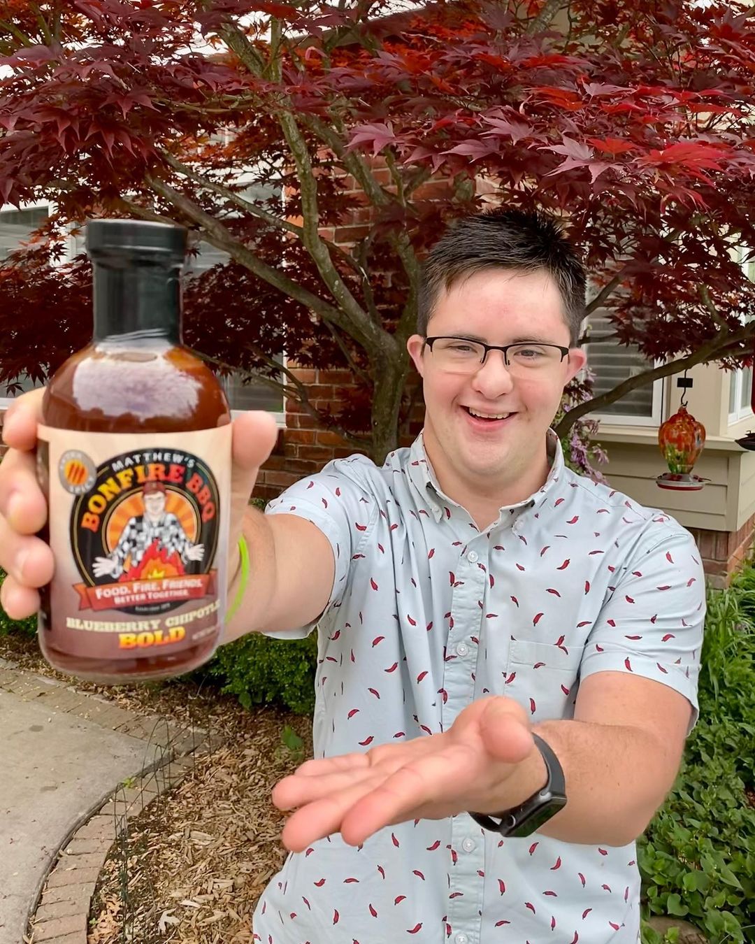 Matthew holding up a bottle of hot sauce
