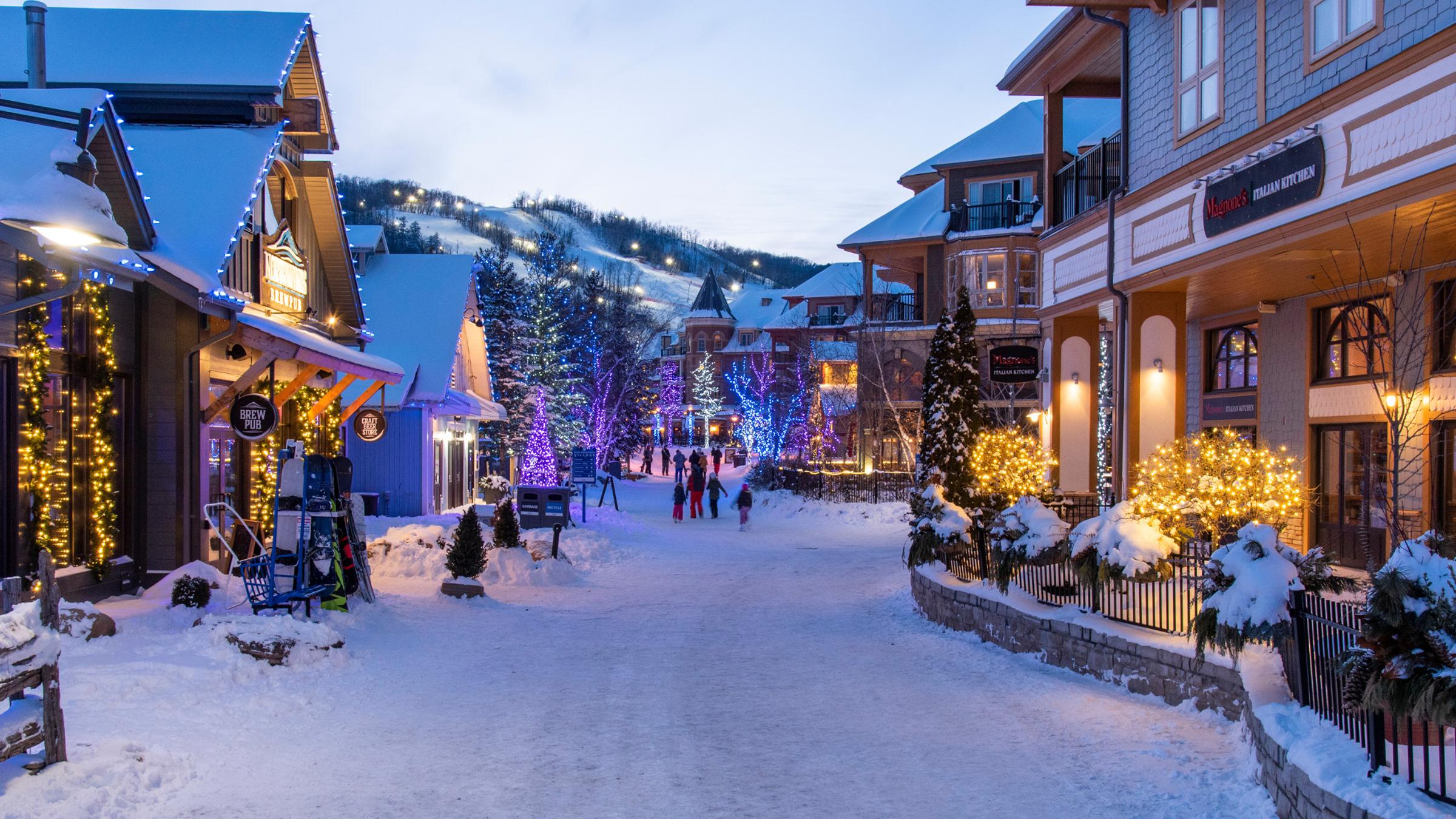 evening exterior of blue mountain resort with snowy streets and little shops all around
