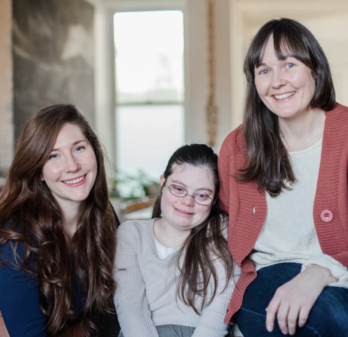 3 interabled women smile as they hug
