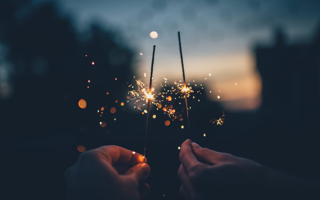 two people holding sparklers