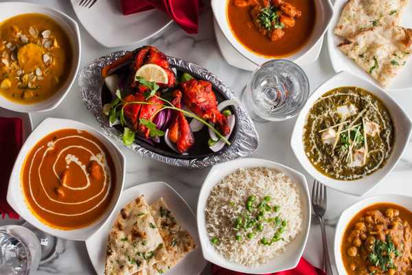 Overhead shot of a dining table filled with various and colorful Indian dishes