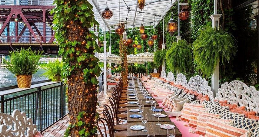 Indoor patio with lots of greenery and low counter tables. Beautiful colorful decor