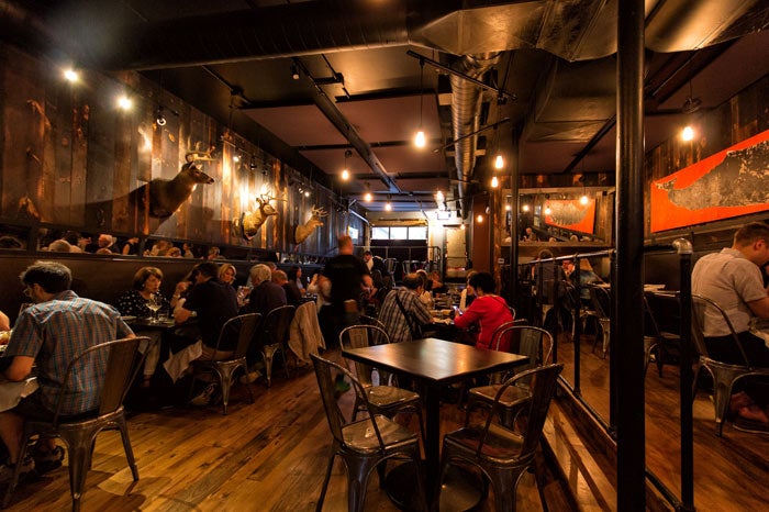 Indoors of The Whalesbone. Low-top tables, wooden flooring, darker interiors, moody vibes.