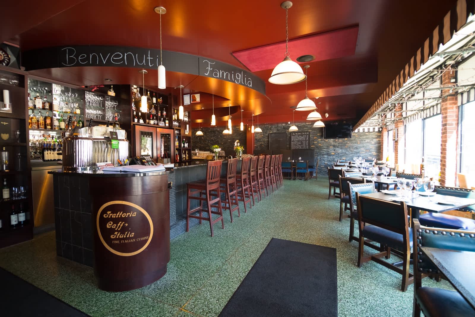 Inside Trattoria Caffe Italia. Spacious, low-top counters. Sign that reads "Benvenuti Familia" 