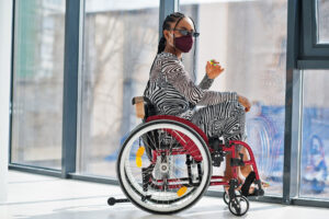 young black and disabled stylish woman in a red manual wheelchair