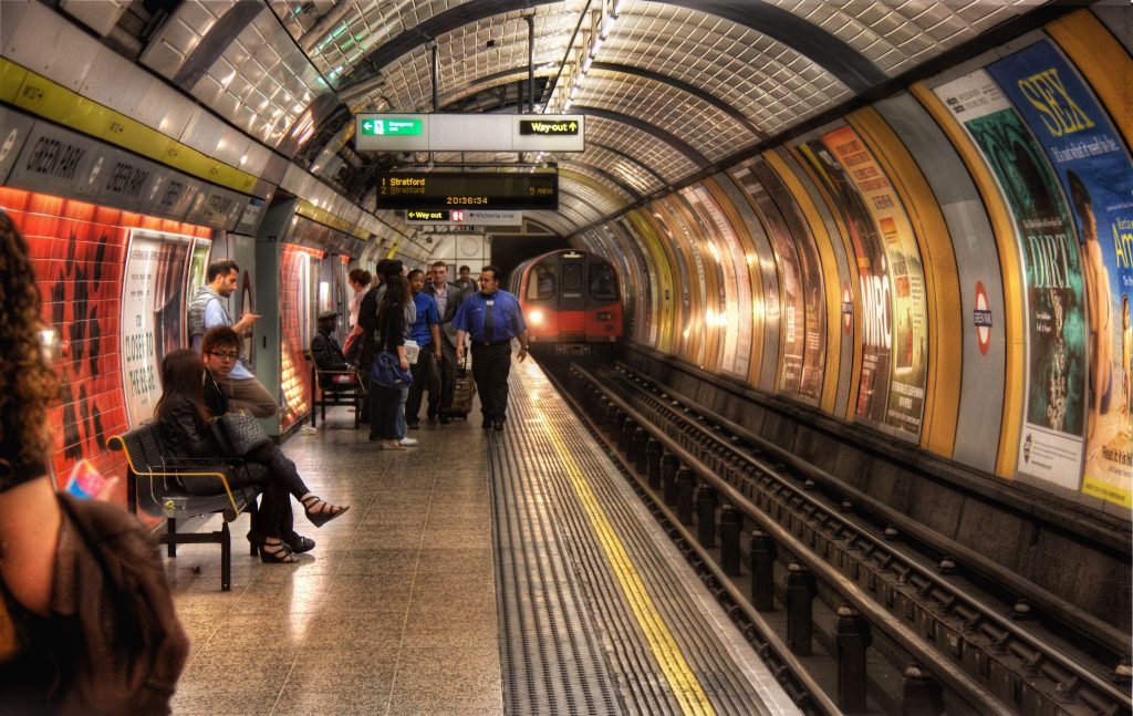 Busy london underground with incoming train on the platform