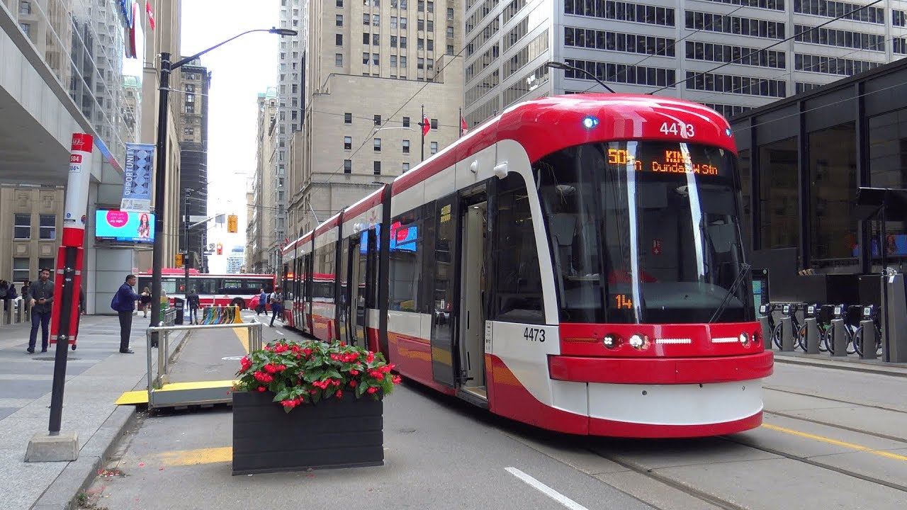 white and red street car in downtown toronto