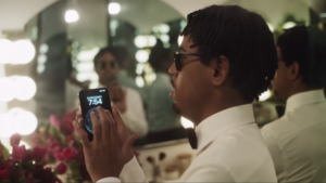 blind man in a tuxedo uses his iphone