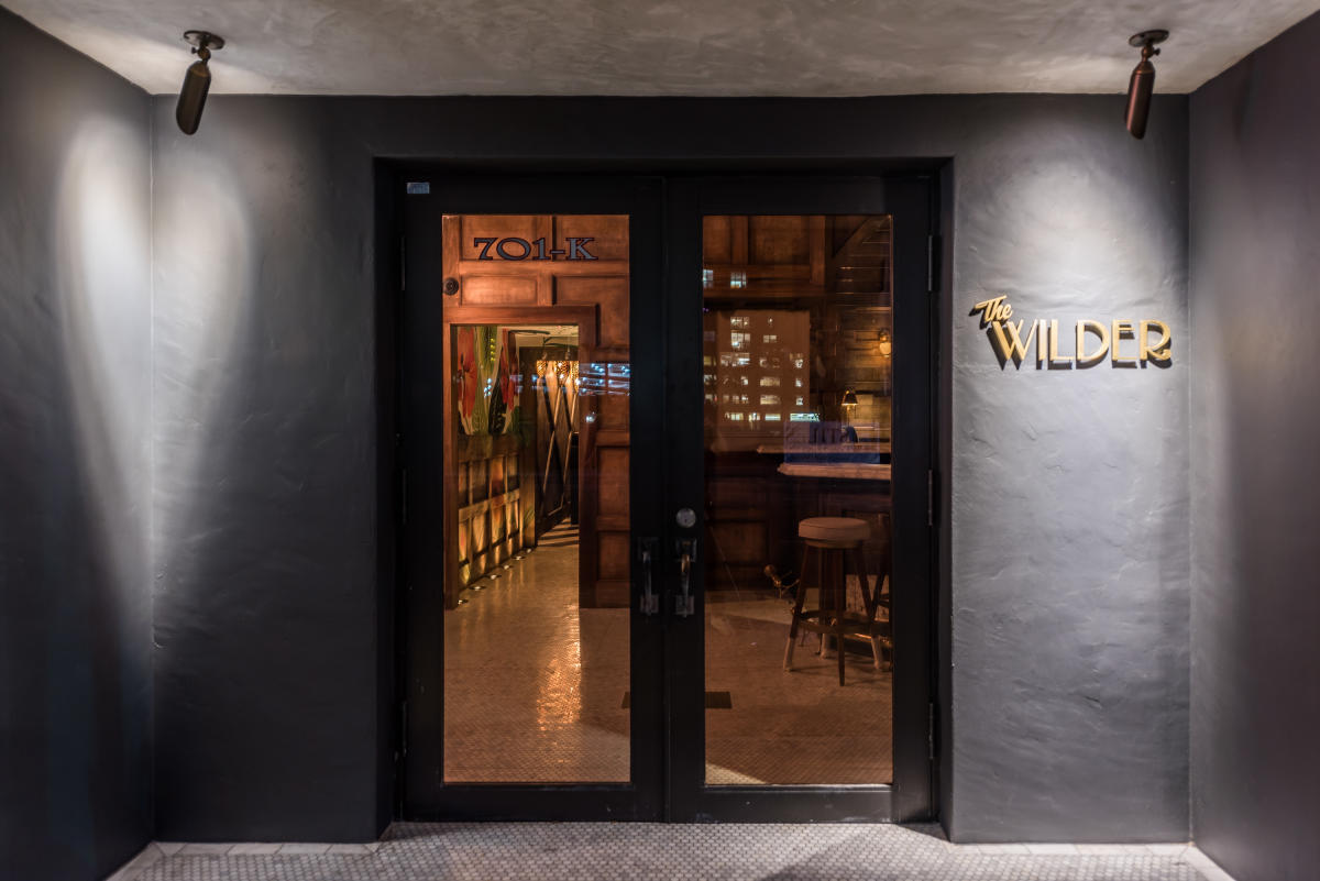 glass doors to the restaurant with the title "the wilder" on the wall