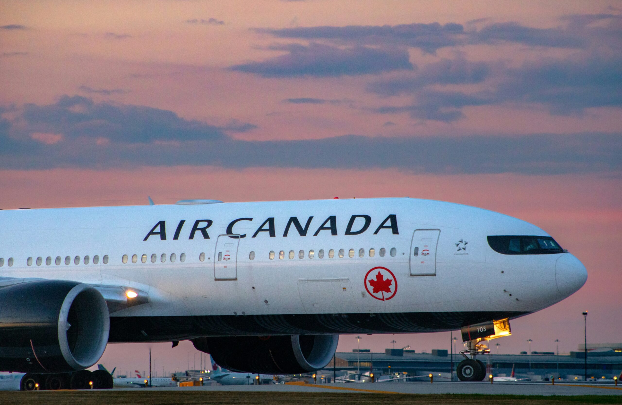 Air Canda aircraft parked with the sunset in the background.