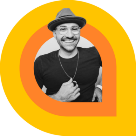 SPENCER WEST SMILES IN A HAT, FRAMED BY AN ORANGE PIN ICON