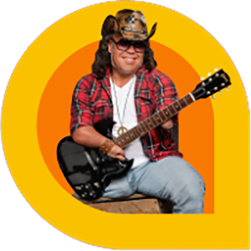 Martin Deschamps, a musician with long curly hair, wears a cowboy hat, sunglasses, and a red plaid shirt while smiling and playing a black electric guitar. He is seated on a wooden crate, framed by bold orange and yellow graphic rings.