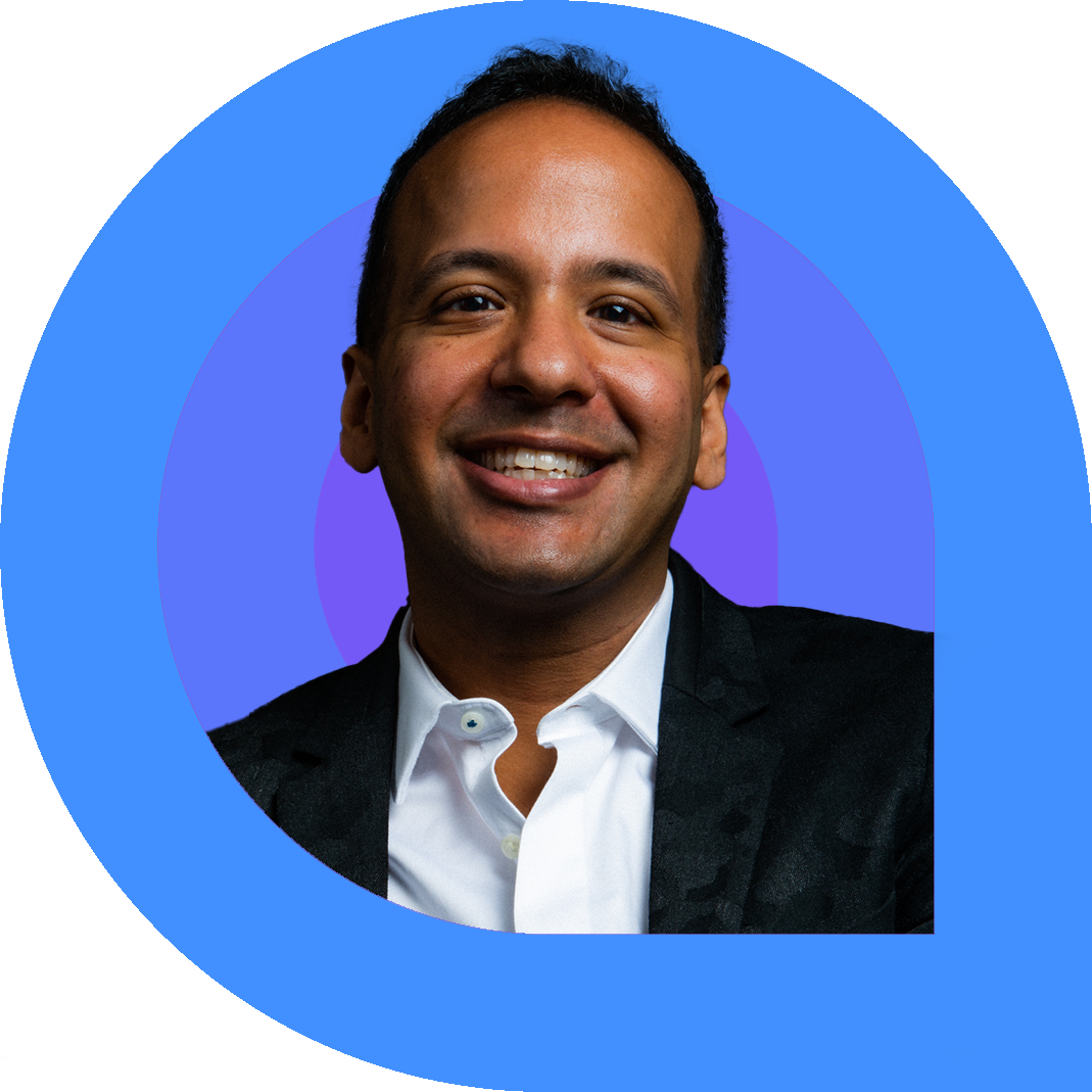 Prasanna, a man with short dark hair, smiles brightly while wearing a white button-down shirt and a black jacket.