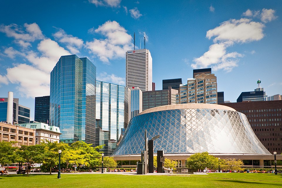 960px-Shiny_buildings_in_Toronto A sunny view of downtown Toronto with Roy Thomson Hall in the foreground. The concert hall features a distinctive sloped, domed glass exterior.