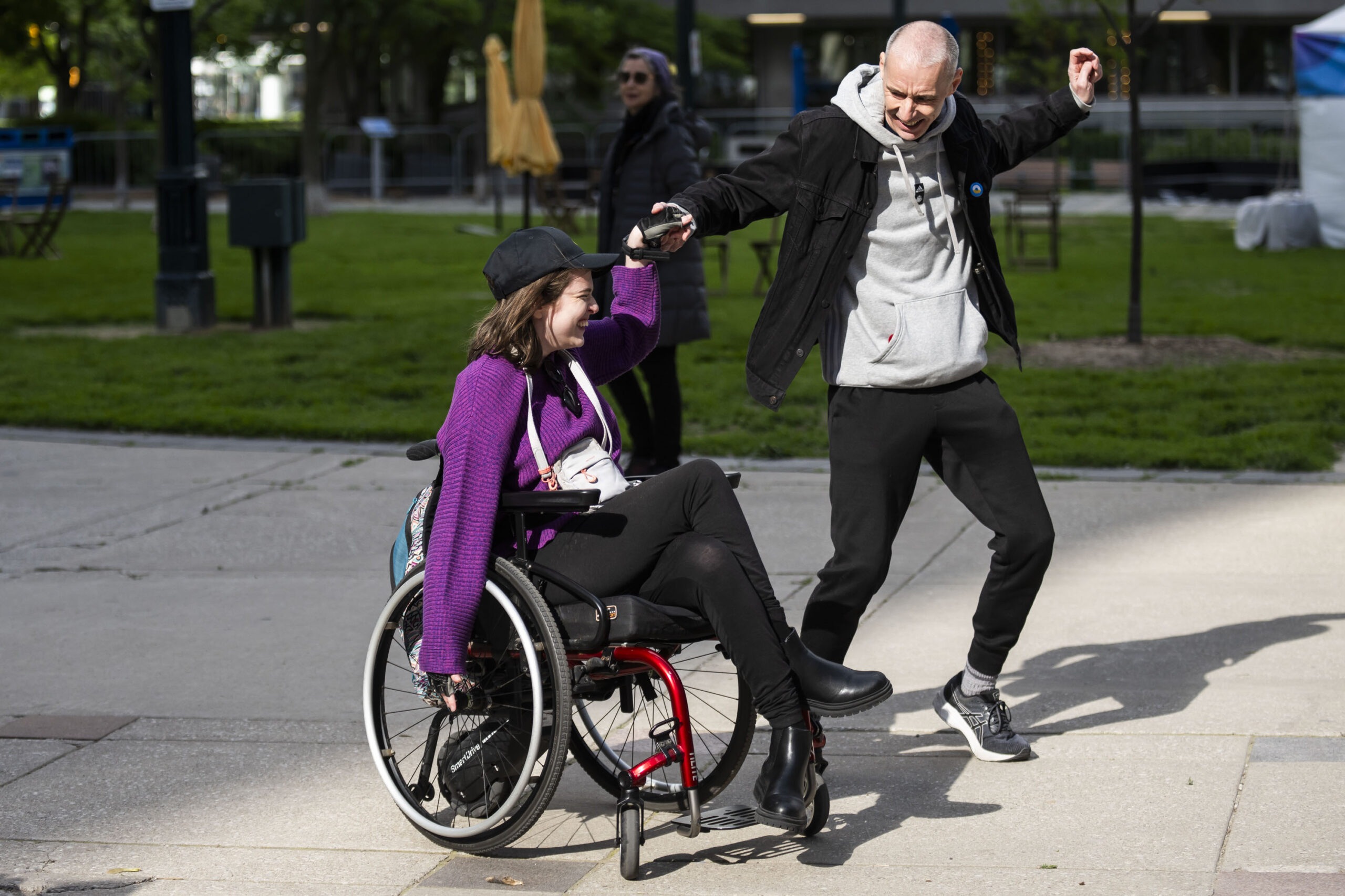 martin deschamps and band all in black on stage at accessfest. martin raises his crutch in the air.