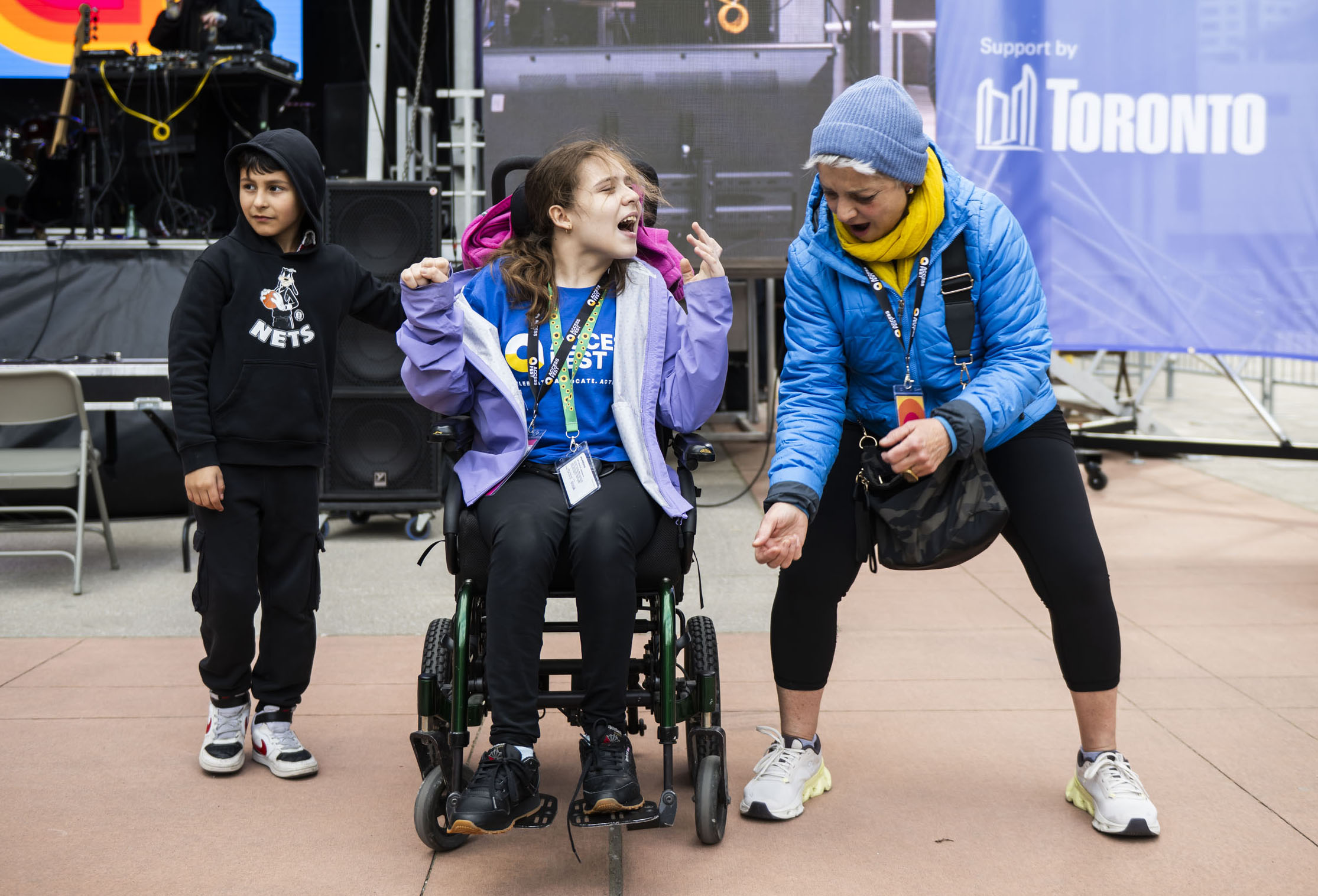 Four people smile while posing with a large golden doodle therapy dog wearing a blue bandana that says “Sunshine Therapy Dogs.”