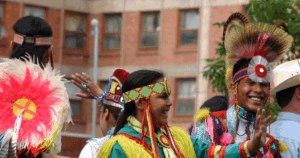 Indigenous peoples celebrating together through sing and dance.