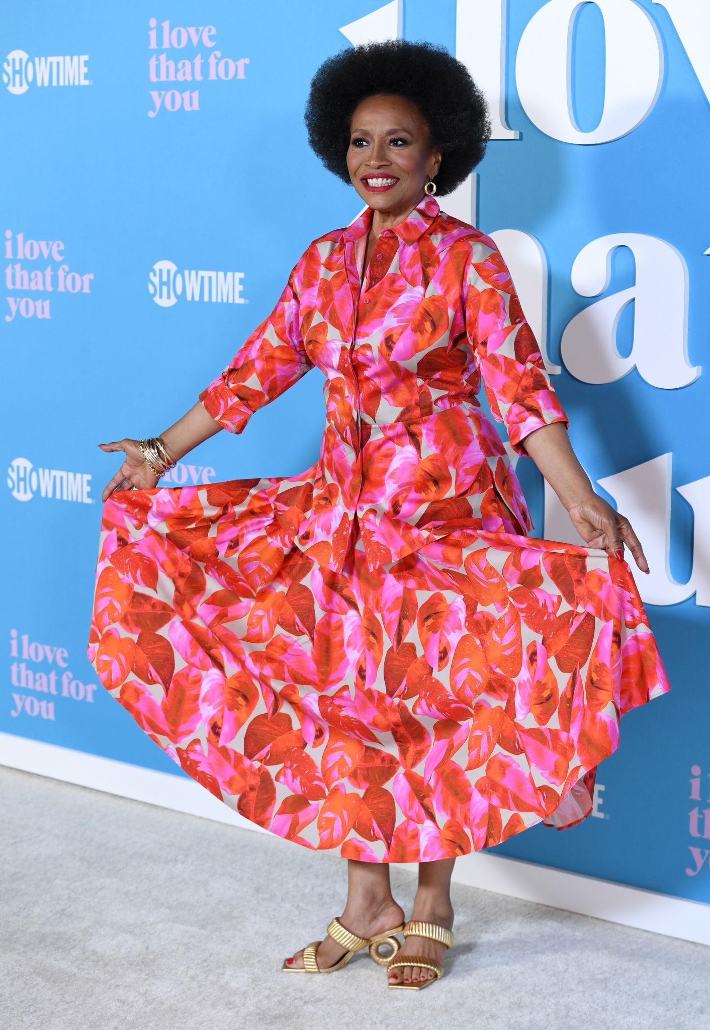 jennifer lewis wearing a bright red and pink dress, smiling 