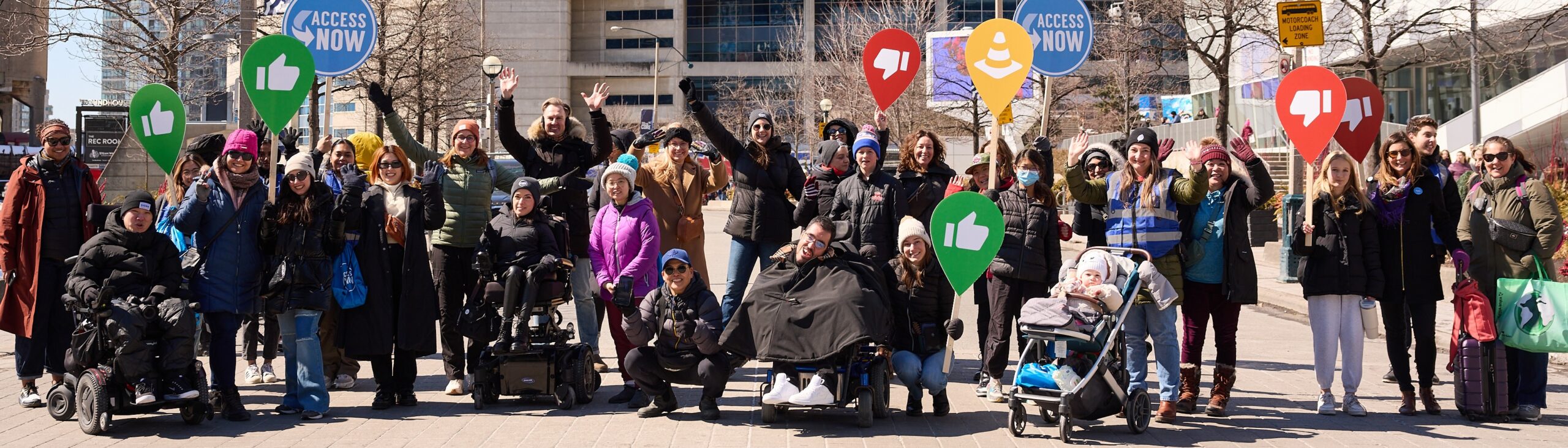 two wheelchair users and a few standing people pose in a green courtyard outside UBC